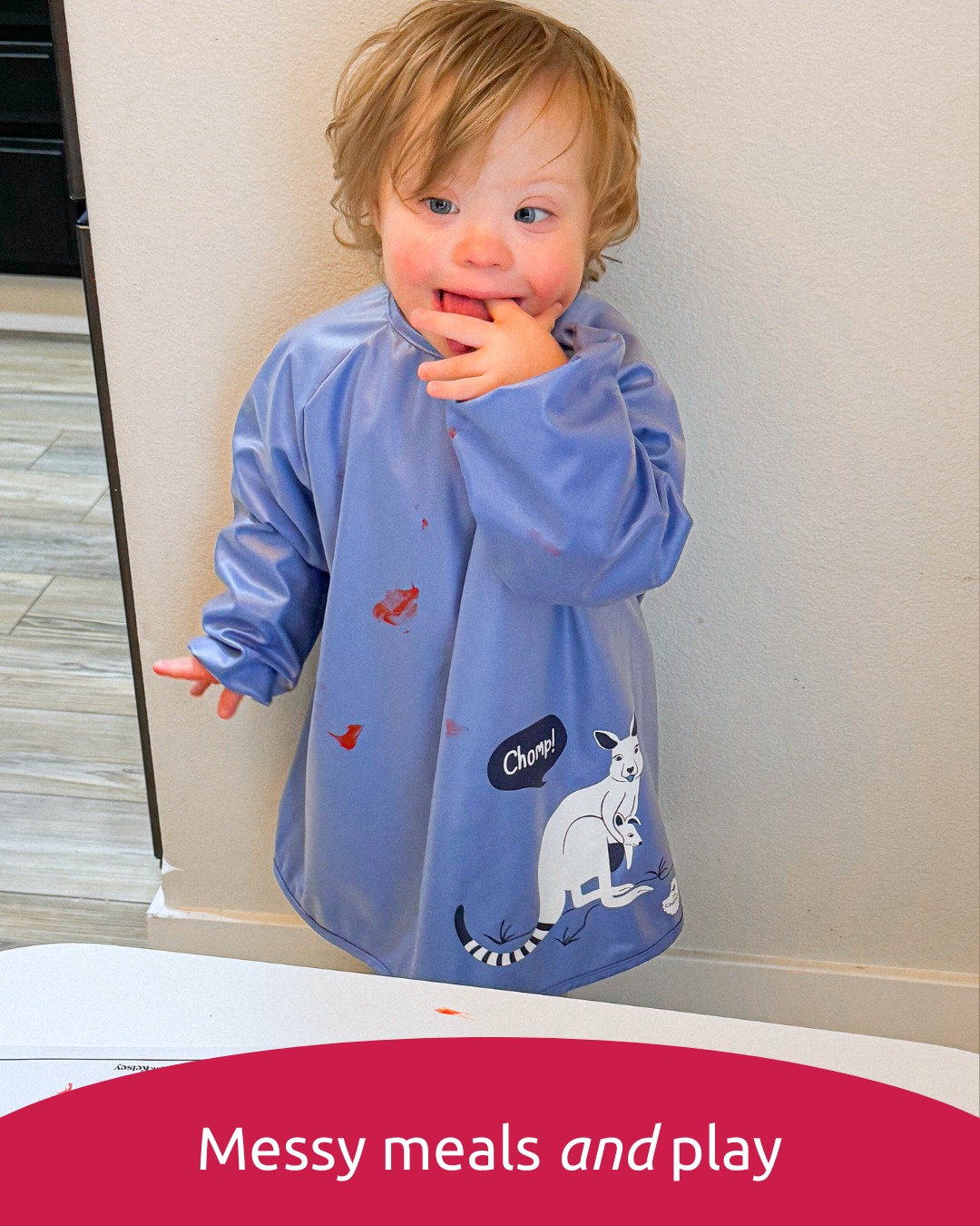 Preschooler wearing a blue disability bib smock.
