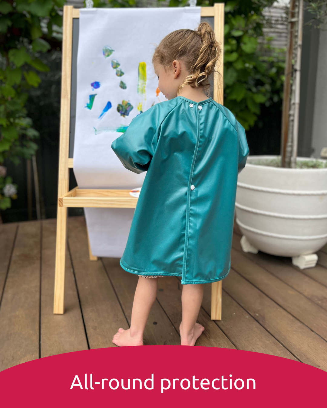 Girl painting wearing a green art smock.