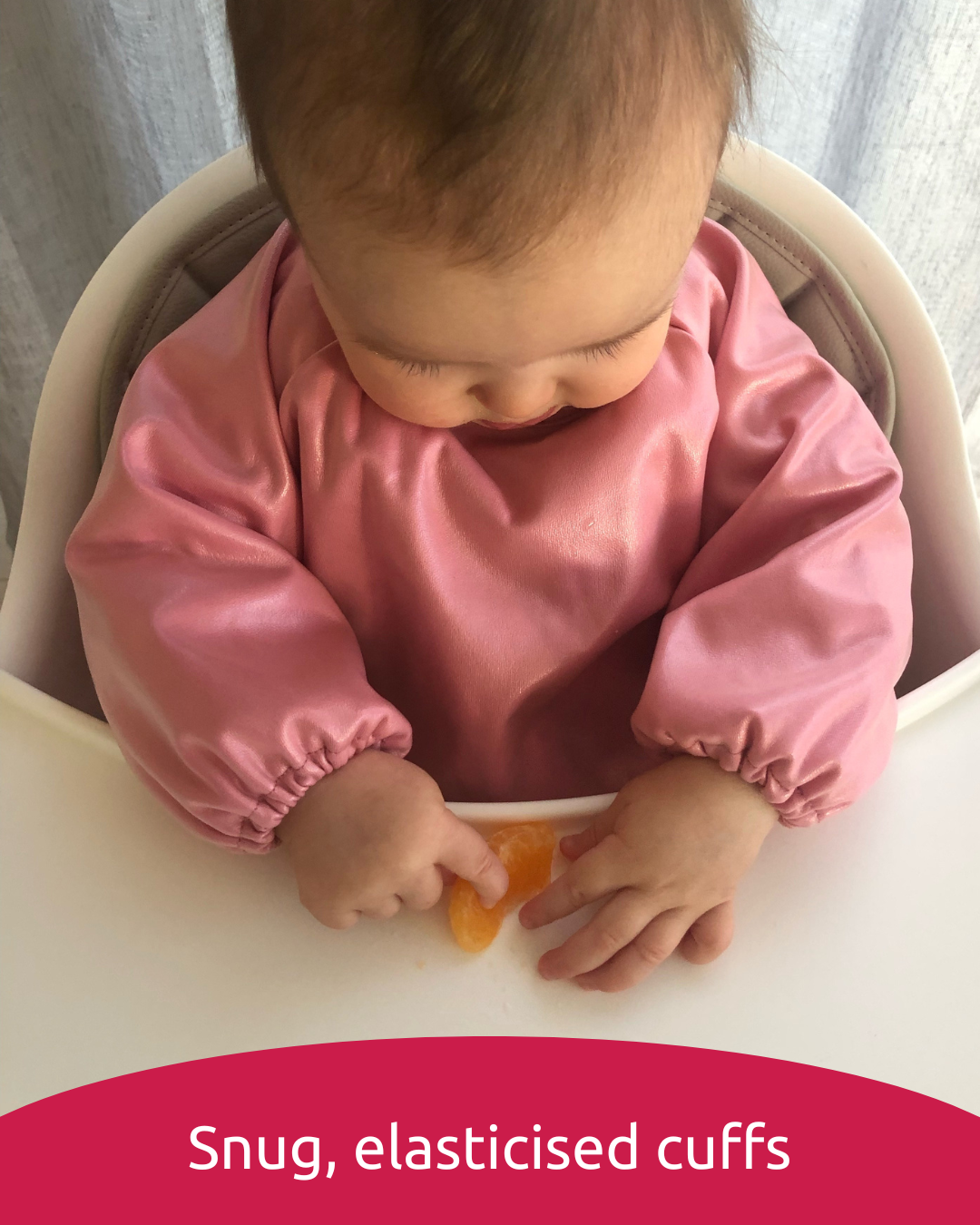 Baby wearing a pink baby smock bib with snug cuffs.
