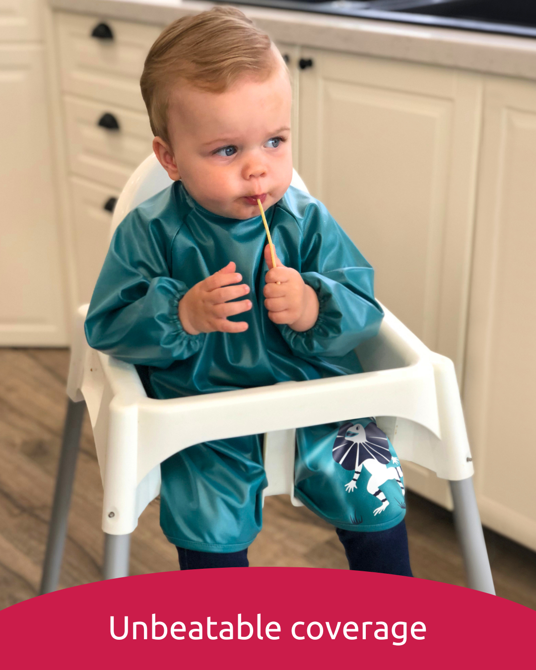 Baby led weaning in green feeding smock.