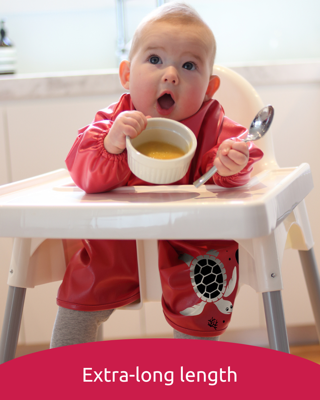 Baby wearing red extra long baby feeding smock.
