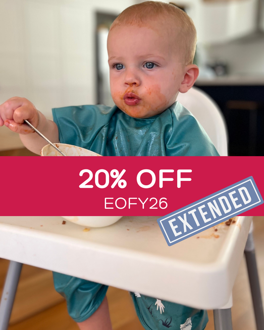 Boy wearing a short sleeve bib smock in green.