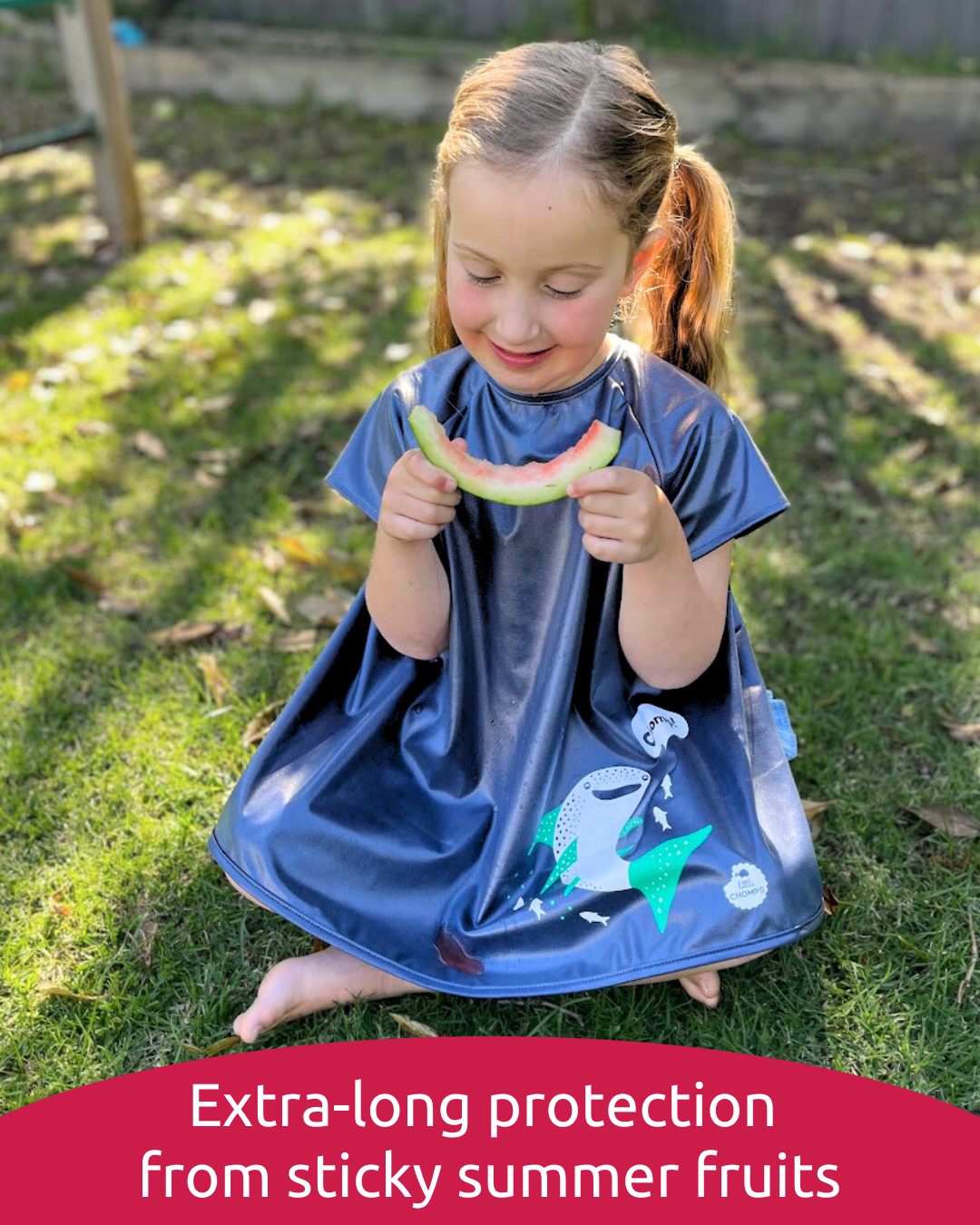 Girl wearing short sleeve smock bib eating watermelon.