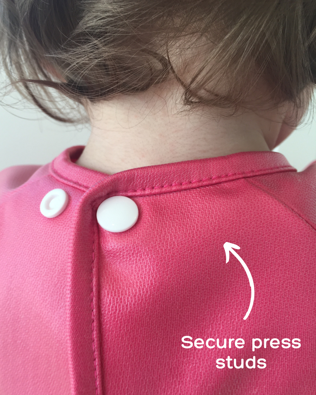 Secure press studs on pink smock.