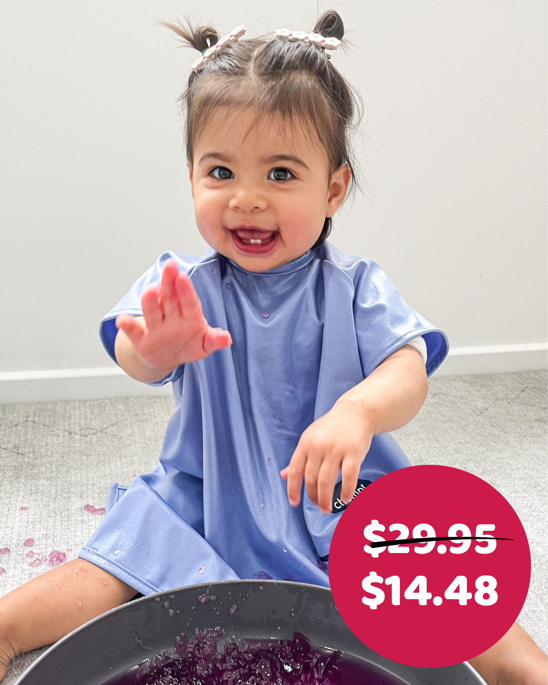 Girl playing with jelly in blue smock bib.