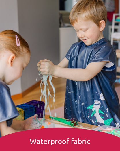 Boy and girl playing with water wearing waterproof art smocks.
