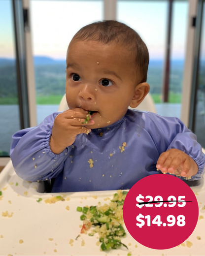 Boy baby led weaning in blue feeding smock.